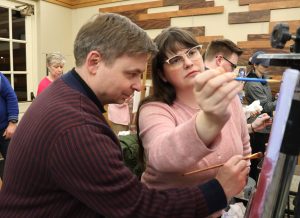 Nathan Baker, left, and his wife, Meagan Stark, work on different parts of their painting.