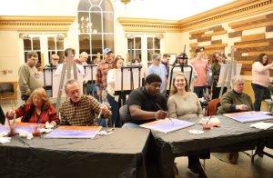 Participants work on their paintings in the lobby of Annie Hogan Byrd Fine Arts Center.