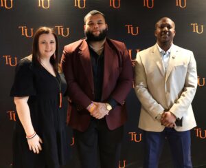 Tusculum student Xavier Velazquez, center, who filmed a segment in “The College Tour” episode, is flanked by April Grindstaff, right, manager of The Tusculum Campus Store, and Chuck Sutton, dean of student and interim associate vice president of student affairs.