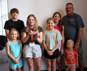 Makayla Stetson, third from the left, holds an art piece she created while she stands with her family.