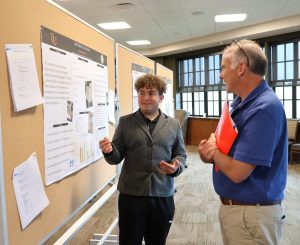 Elijah Garland, left, shows his poster to Dr. David Smith.