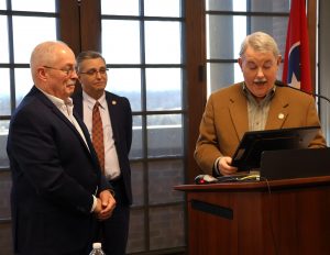 Dr. Greg Nelson, right, reads the resolution as Dr. Scott Hummel, center, and Dale Long listen.