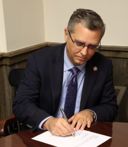 Dr. Scott Hummel signs the document.