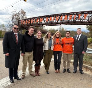 Members of the Pilloni family pose by the sign.