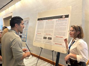 Emme Foster, right, discusses her poster at the conference.
