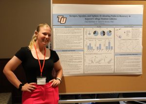 Dani Beckham stands by her poster at the symposium.