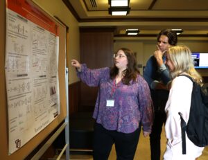Student Skylar Lane, left, discusses her poster with fellow Pioneers.
