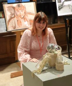 Hannah Morgan crouches by her art.