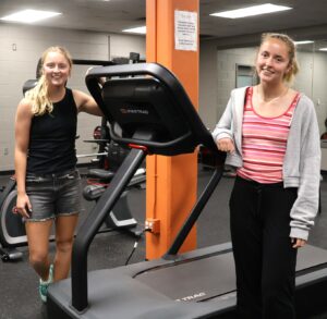 Identical twins Olivia Browne, left, and Morgan Browne stand in The Wellness Center at Tusculum University.